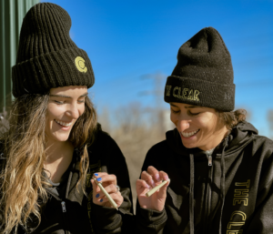 Two women are enjoying two pre-roll joints.