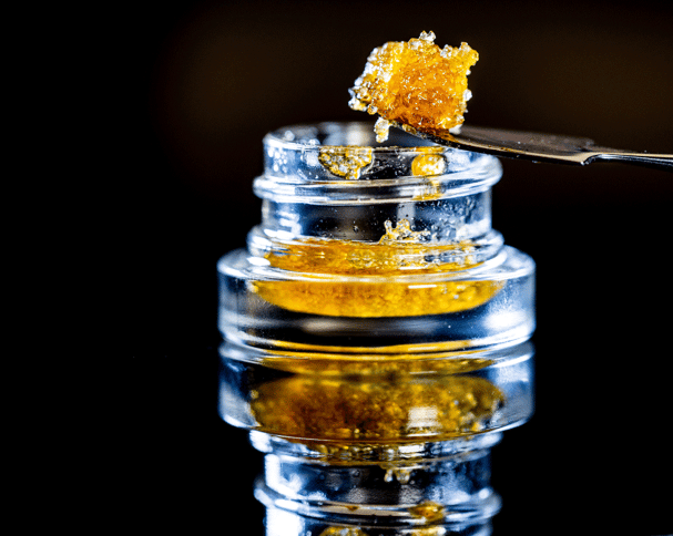 Hydrocarbon live resin is scooped out of the jar with a spoon.
